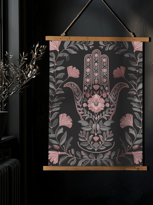 Botanical Hamsa wall tapestry featuring intricate rose gold and teal design on black background, showing a protective hand symbol surrounded by leaf motifs and floral elements, hanging from wooden dowels with natural twine.